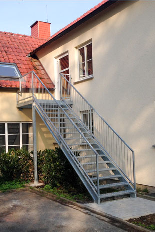 Außentreppe als Zugang zu einem Heim, inklusive beidseitigem Geländern und einer Stütze unter dem Podest. Laufbreite 1200mm auf Wangen aus C Profilen